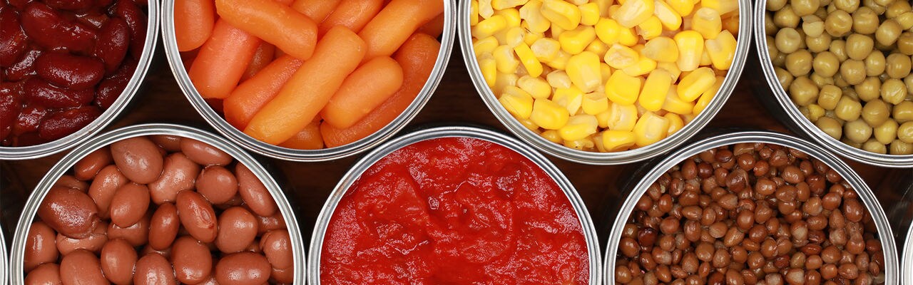 Different kinds of vegetables such as corn, peas and tomatoes in cans