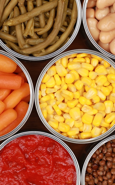 Different kinds of vegetables such as corn, peas and tomatoes in cans