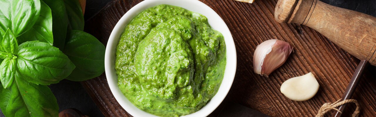 Pesto sauce cooking. Basil, olive oil, parmesan, garlic, pine nuts. Top view on dark stone table