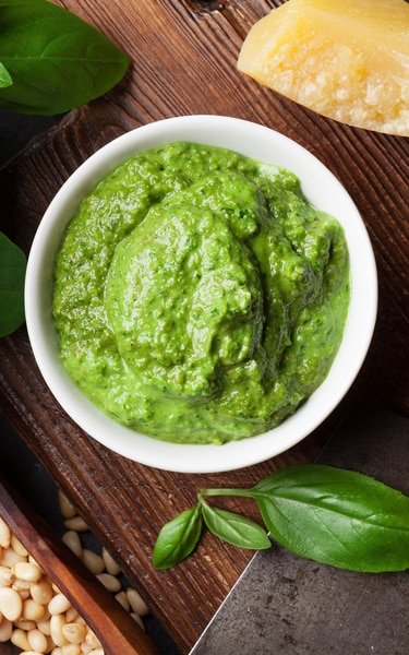 Pesto sauce cooking. Basil, olive oil, parmesan, garlic, pine nuts. Top view on dark stone table