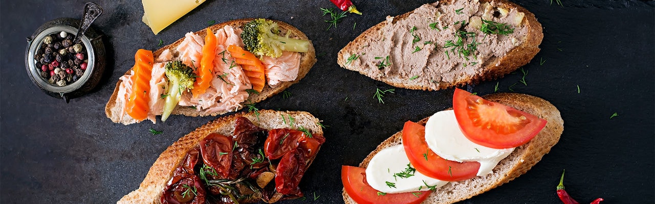Variety of healthy sandwiches on a dark background in a rustic style. Top view