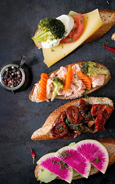 Variety of healthy sandwiches on a dark background in a rustic style. Top view