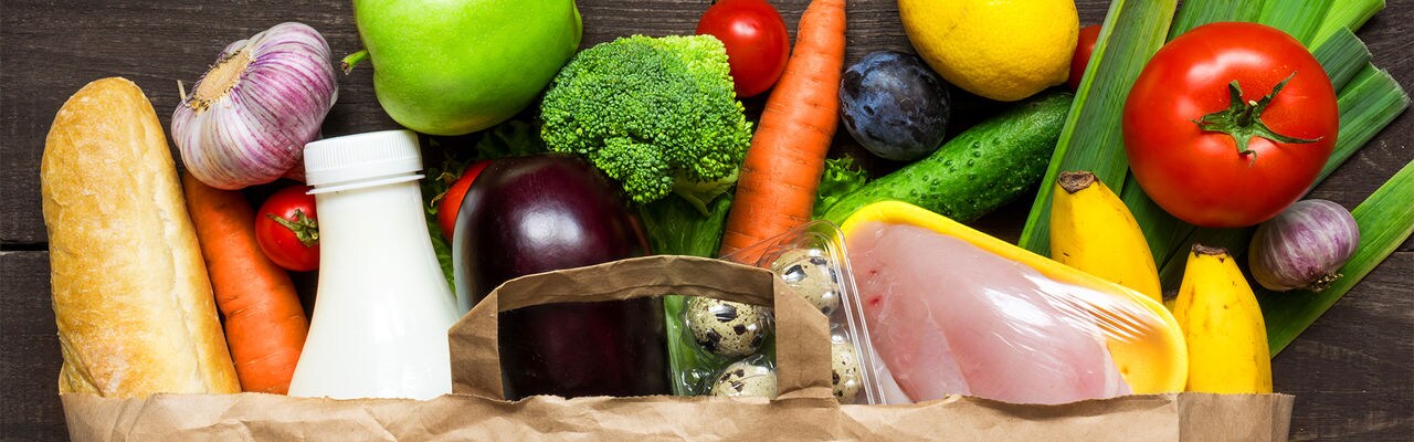 Full paper bag of different health food on rustic wooden background. Top view. Flat lay